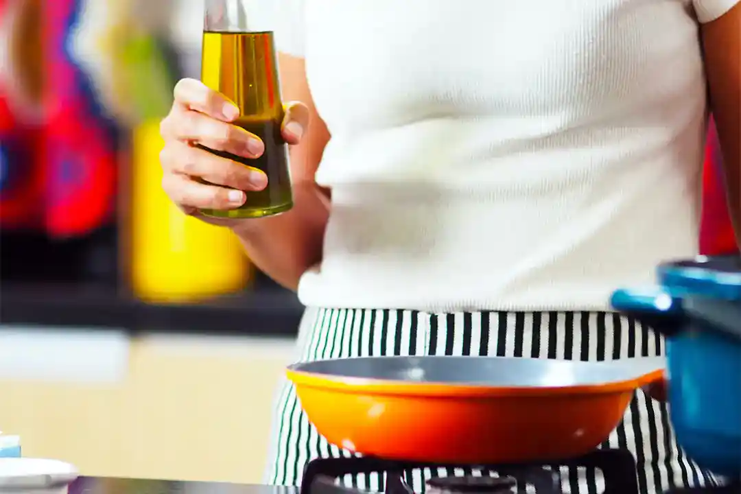 Female chef holding a bottle of cannabis cooking oil