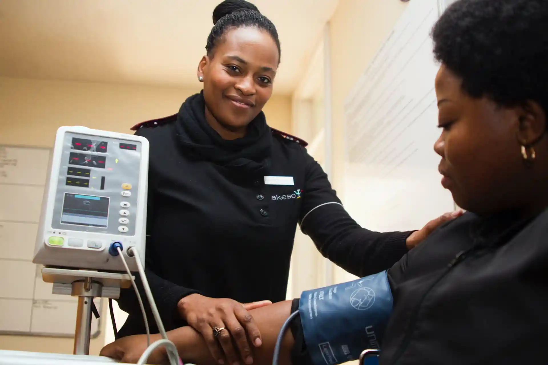 black female nurse assisting black female patient