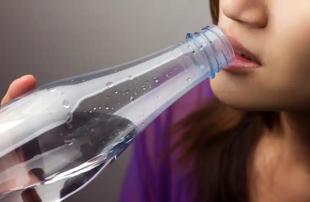 Woman drinking water from a plastic bottle