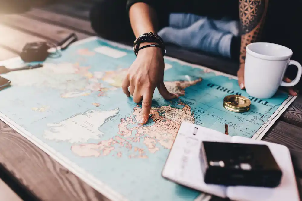 Hand pointing at a map on a desk