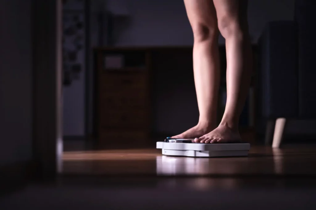 woman standing on a bathroom scale