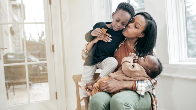 Stressed Boynton Beach mom soothing her two young children while trying to stay calm during an overwhelming moment.